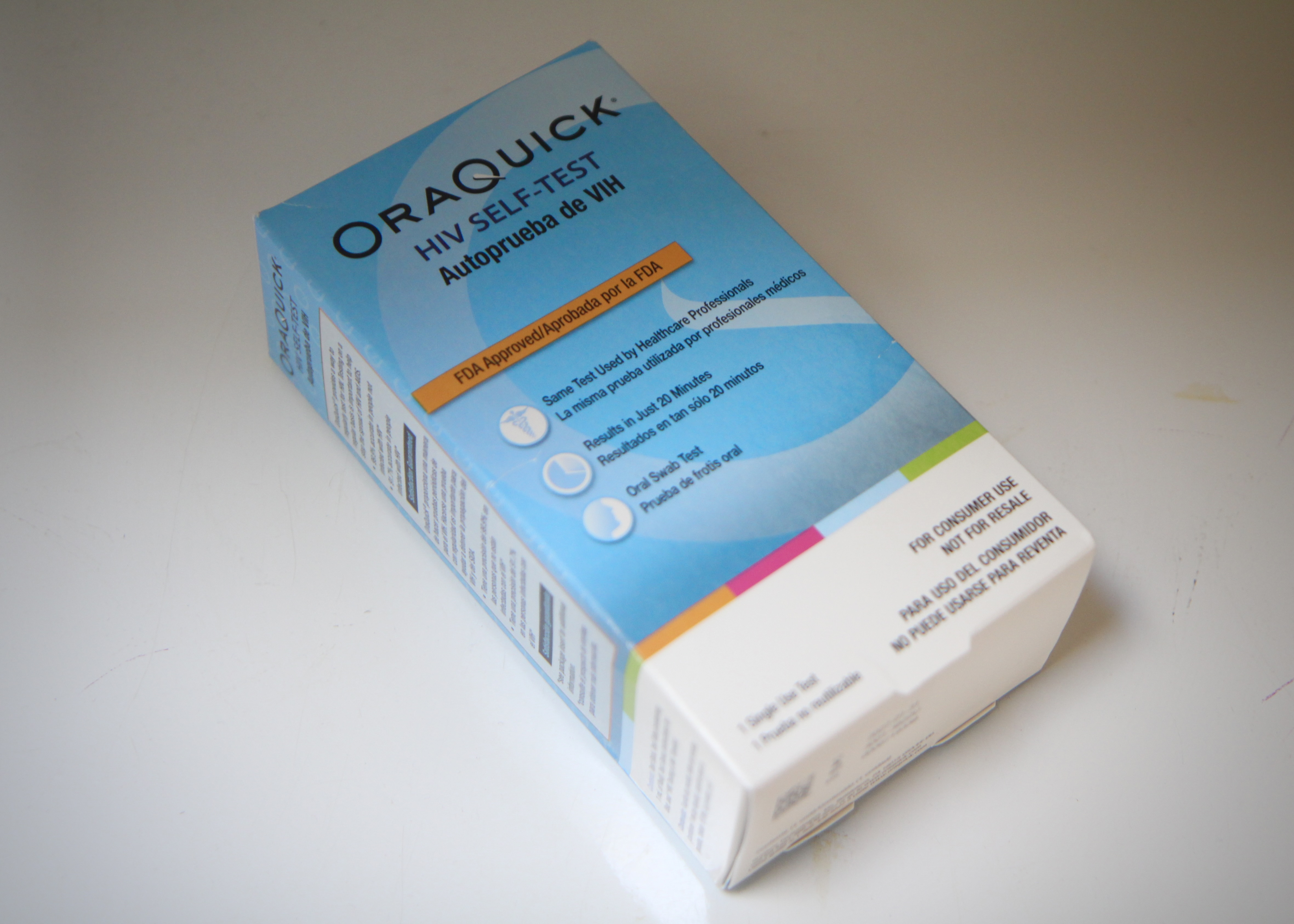 A blue and white box containing an HIV self-test kit sits atop a solid white surface.